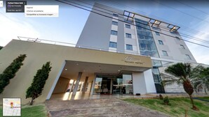 The exterior of Portinho Palace Hotel with a modern design, featuring a prominent entrance and a glass facade. - Hotel Portinari (Vilhena)
