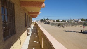 A building with a tiled balcony overlooking a street. - Hotel Plaza Peñasco (Puerto Peñasco)