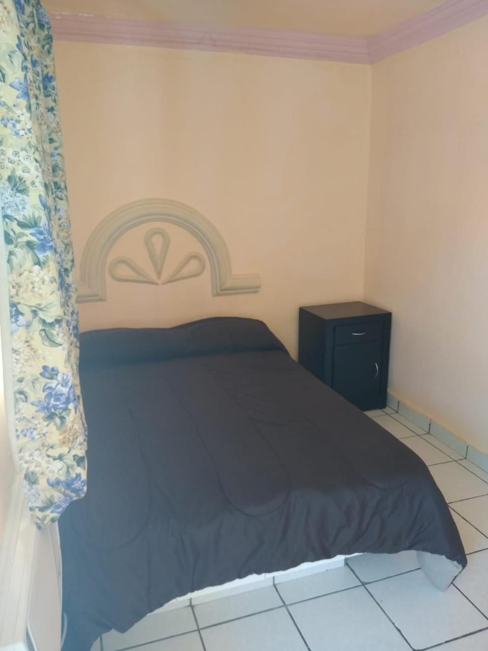Une chambre à coucher avec un lit, une table de chevet et une tête de lit.