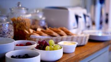 Ein Frühstücksbuffet mit einer Auswahl an Früchten, Käse und Brot.