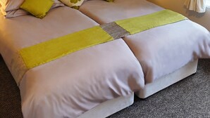 A double bed with two pillows, a bedside table with a lamp, and a wall-mounted artwork. - Borthwen B&B (Dolgellau)