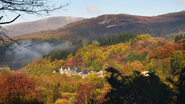 A house surrounded by autumn foliage with a mountainous backdrop. - Borthwen B&B (Dolgellau)