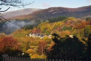 A house surrounded by autumn foliage with a mountainous backdrop. - Borthwen B&B (Dolgellau)