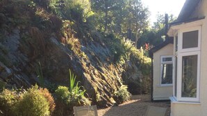 A patio area with two folding chairs and a gravel path leading to a house. - Borthwen B&B (Dolgellau)