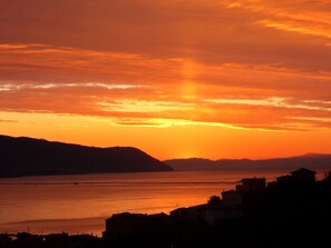 A coastal sunset view with silhouettes of buildings and hills. - Studio in the center of La Spezia 2 steps from the Cinque Terre and Portovenere (La Spezia)