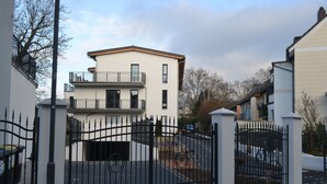 Un área residencial cerrada con casas modernas, un camino de entrada pavimentado y cielo despejado.