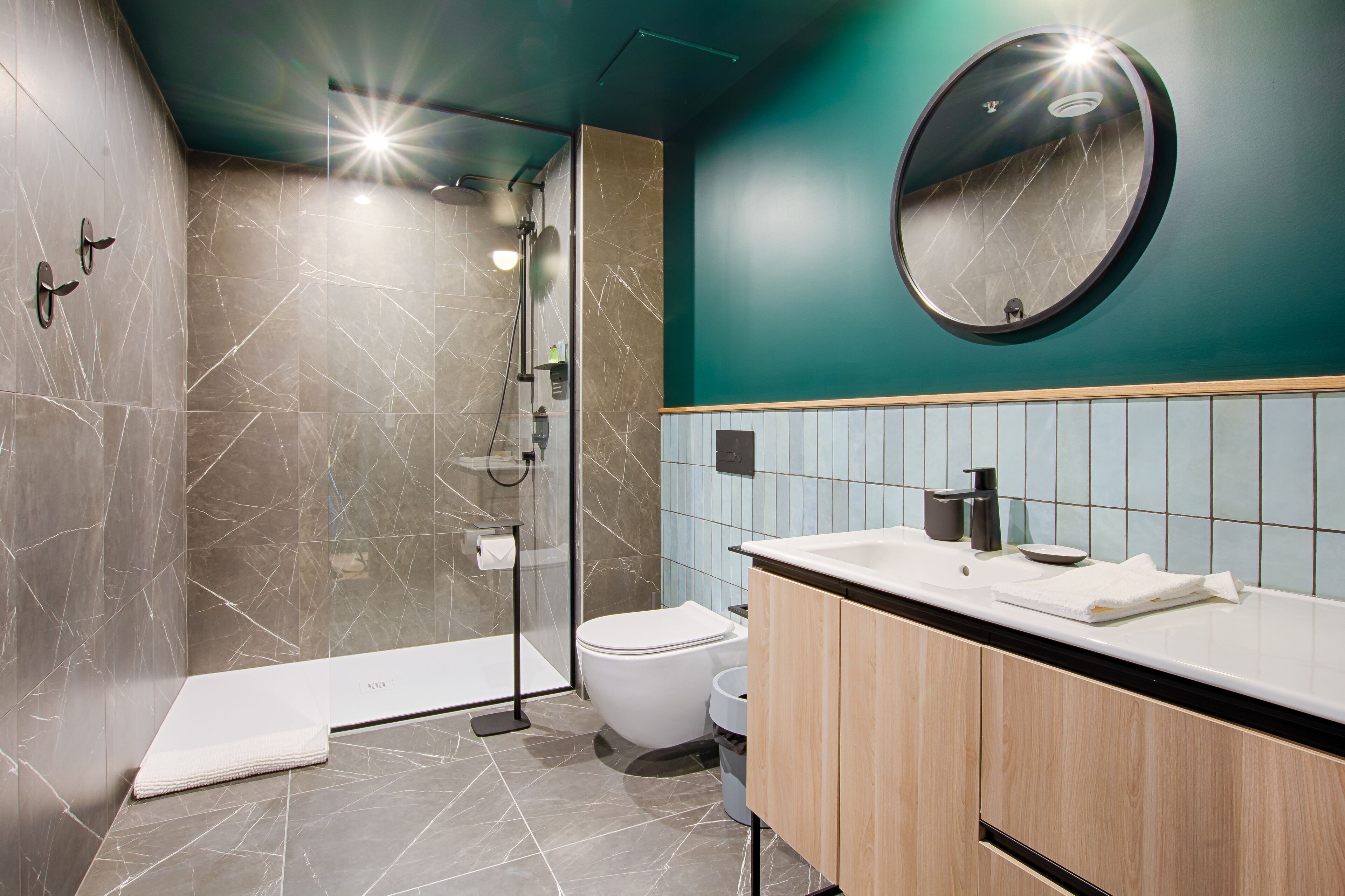 Een moderne badkamer met douche, toilet en wastafel.