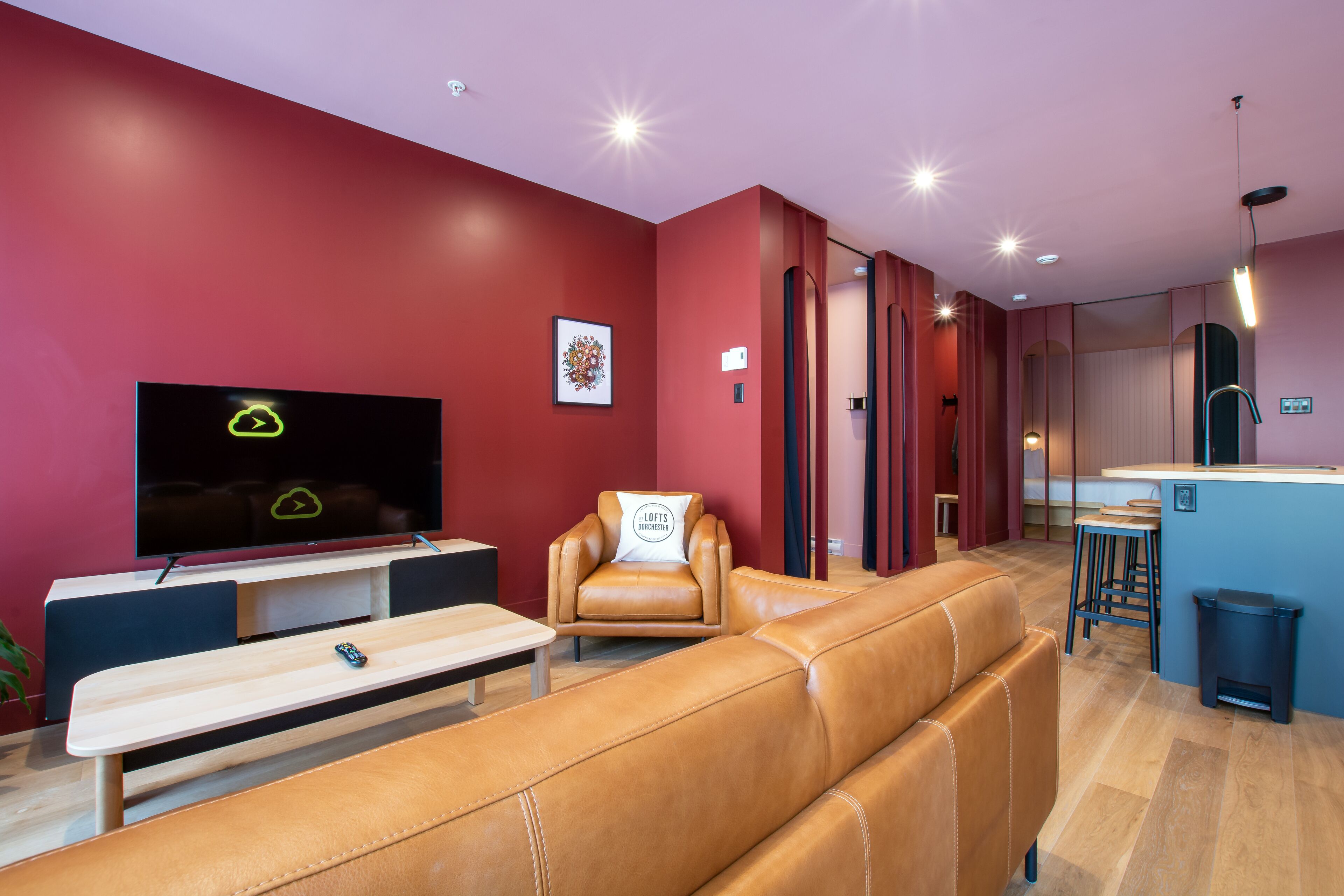Ein modernes Wohnzimmer mit einer Ledersofa, einem Fernseher und einer Bank.