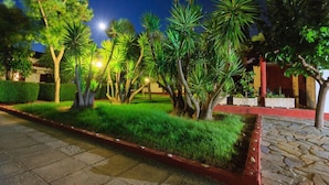A well-maintained garden with various trees and a stone pathway. - Alykes Park Bungalows & Apt (Zakynthos)