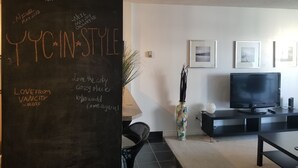 Ein modernes Wohnzimmer mit einer Tafel, auf der '2018 Gästebuch' und 'YTC IN A STYLE' stehen.
