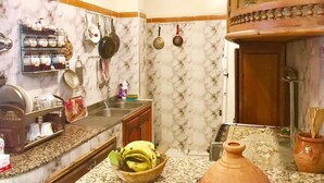 A kitchen with marble walls, a granite countertop, and various kitchen utensils and appliances. - Appart Boutchakkat 1 (Agadir)