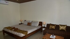Ein Schlafzimmer mit einem Bett, einer Couch, einem Tisch und zwei Lampen.