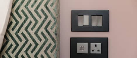 A wall with two electrical outlets and switches, one with USB ports.