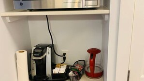 A kitchen with a microwave, coffee maker, and various kitchen utensils. - WindTower Resort @ Cozy Hotel Room (Canmore)