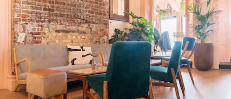 A cozy seating area with a brick wall, a sofa, and a table with chairs.