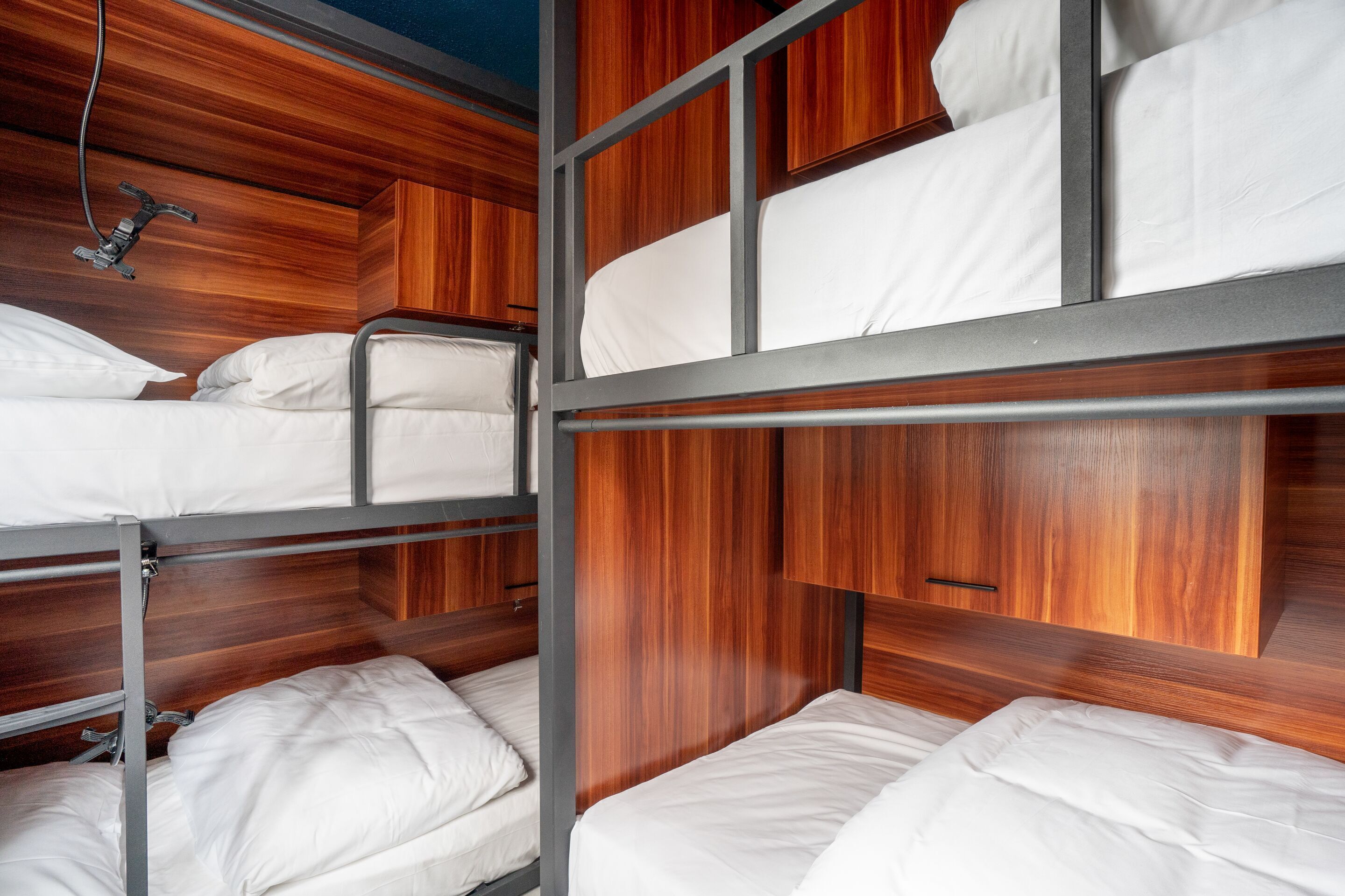 Habitación con literas, paneles de madera y barandillas de metal.