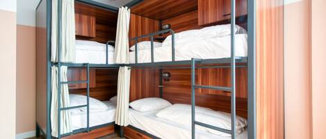 A bunk bed room with wooden paneling and metal railings.