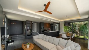 En moderne stue med en stor sofa, et spiseområde og et køkken.