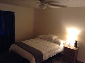 A bedroom with a bed, a nightstand, a lamp, and a ceiling fan. - Convenient 1-Bedroom Apartment Next to Fort Sill (Lawton)