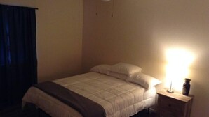 A bedroom with a bed, a nightstand, a lamp, and a ceiling fan. - Convenient 1-Bedroom Apartment Next to Fort Sill (Lawton)