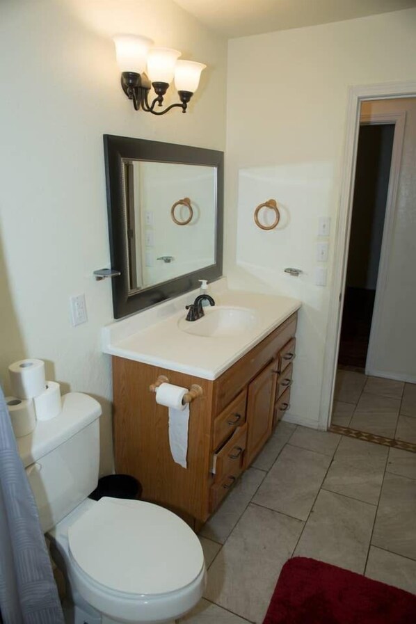 A bathroom with a toilet, sink, mirror, and towel rack. - 14% discount for 1 week 22% discount for 1 month (Lawton)