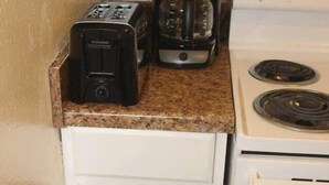 A compact kitchen with a toaster, coffee maker, and a stove. - 1 bedroom apartment within sight of Fort Sill (Lawton)