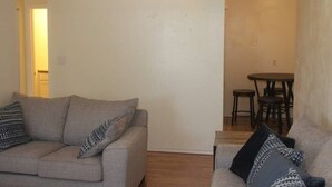A living room with two sofas, a dining table with chairs, and a light fixture on the wall. - 1 bedroom apartment within sight of Fort Sill (Lawton)
