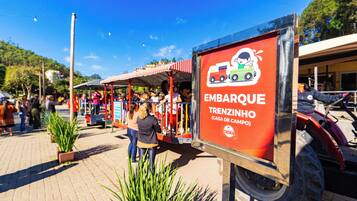 A sign for 'EMBARQUE TRENZINHO' with a logo of a train and a child.
