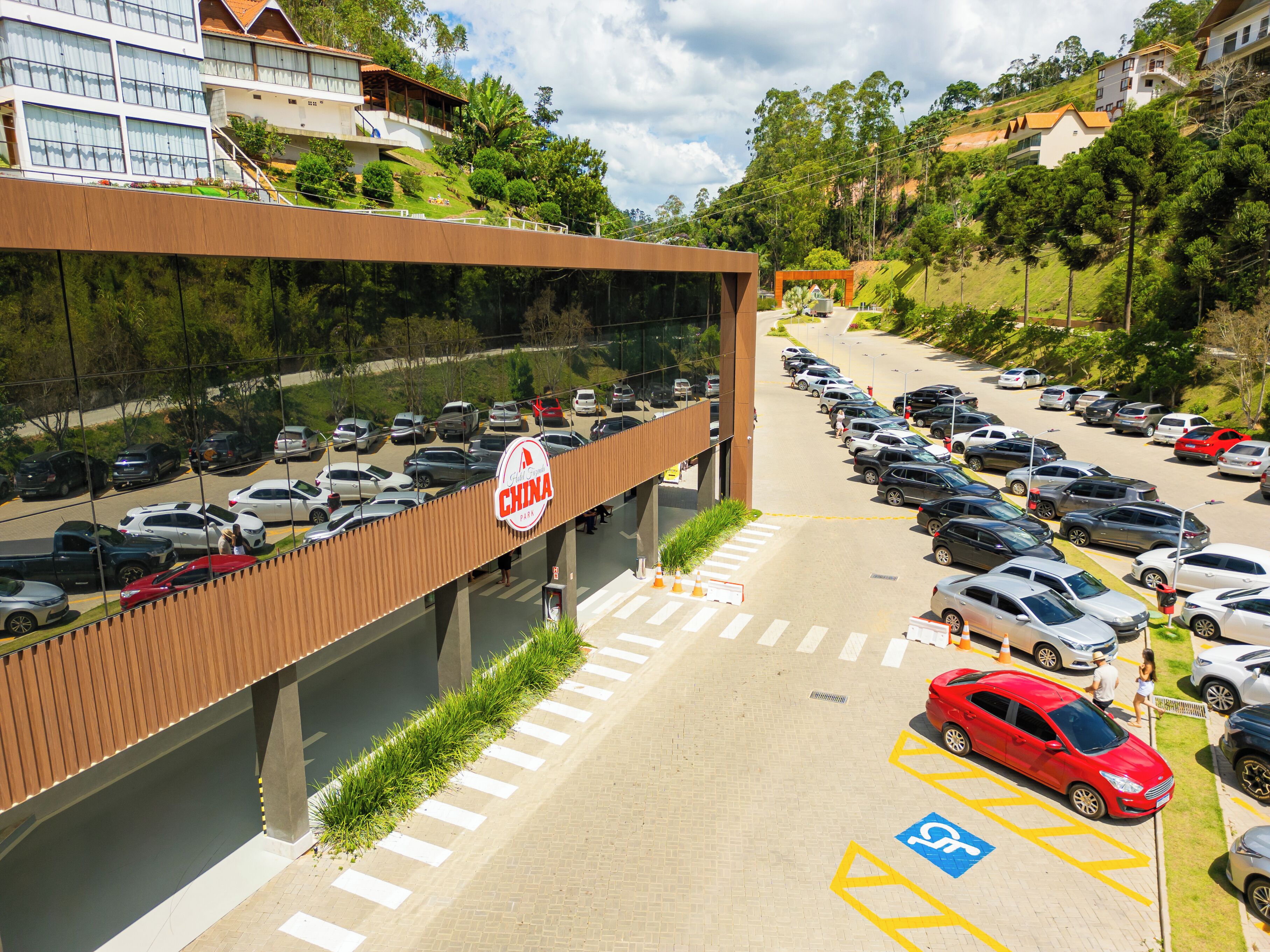 Um estacionamento com carros, uma faixa de pedestres e um edifício com uma placa que diz 'China Para'.