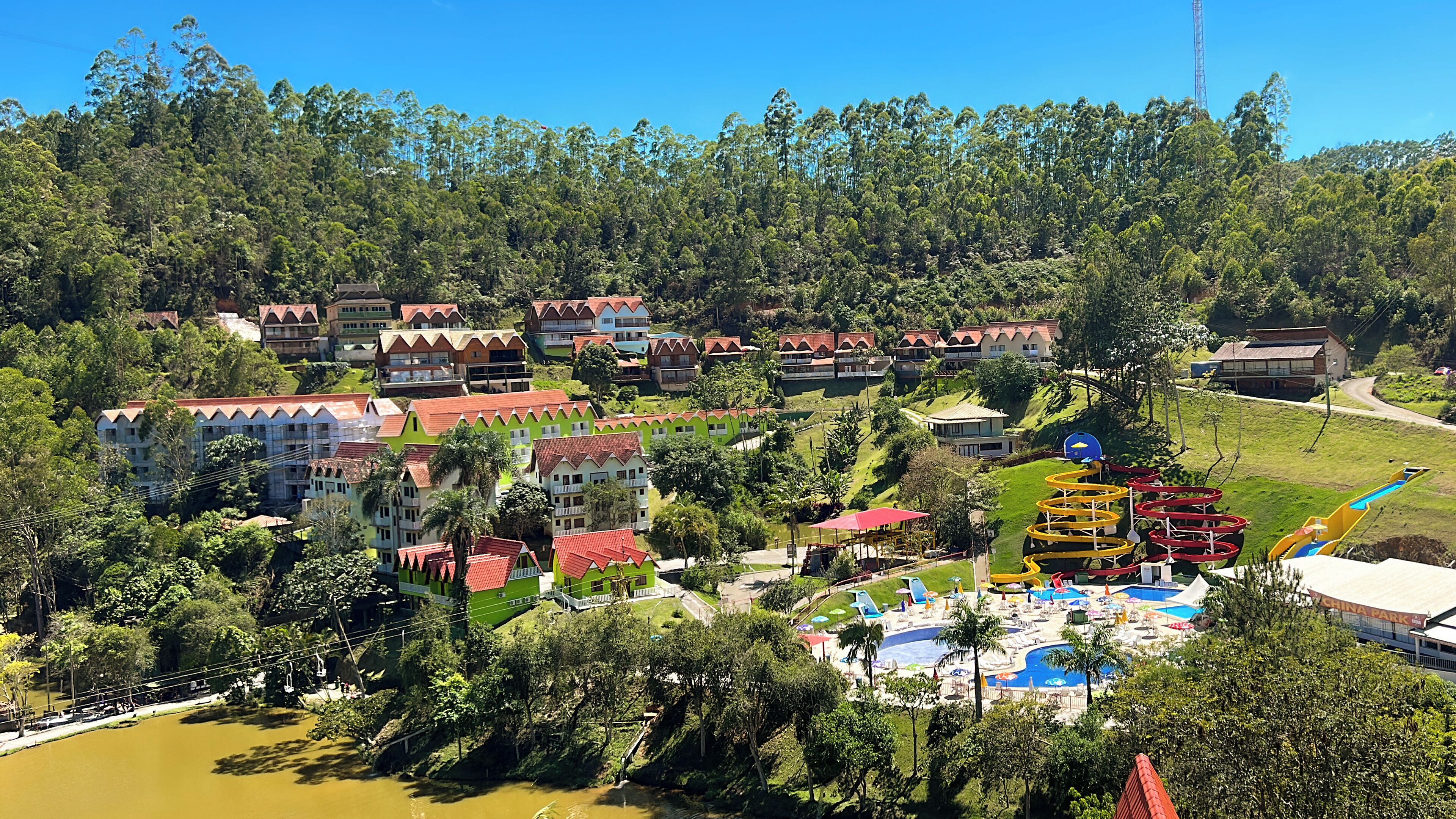 Um resort com vários edifícios, piscina e toboágua.