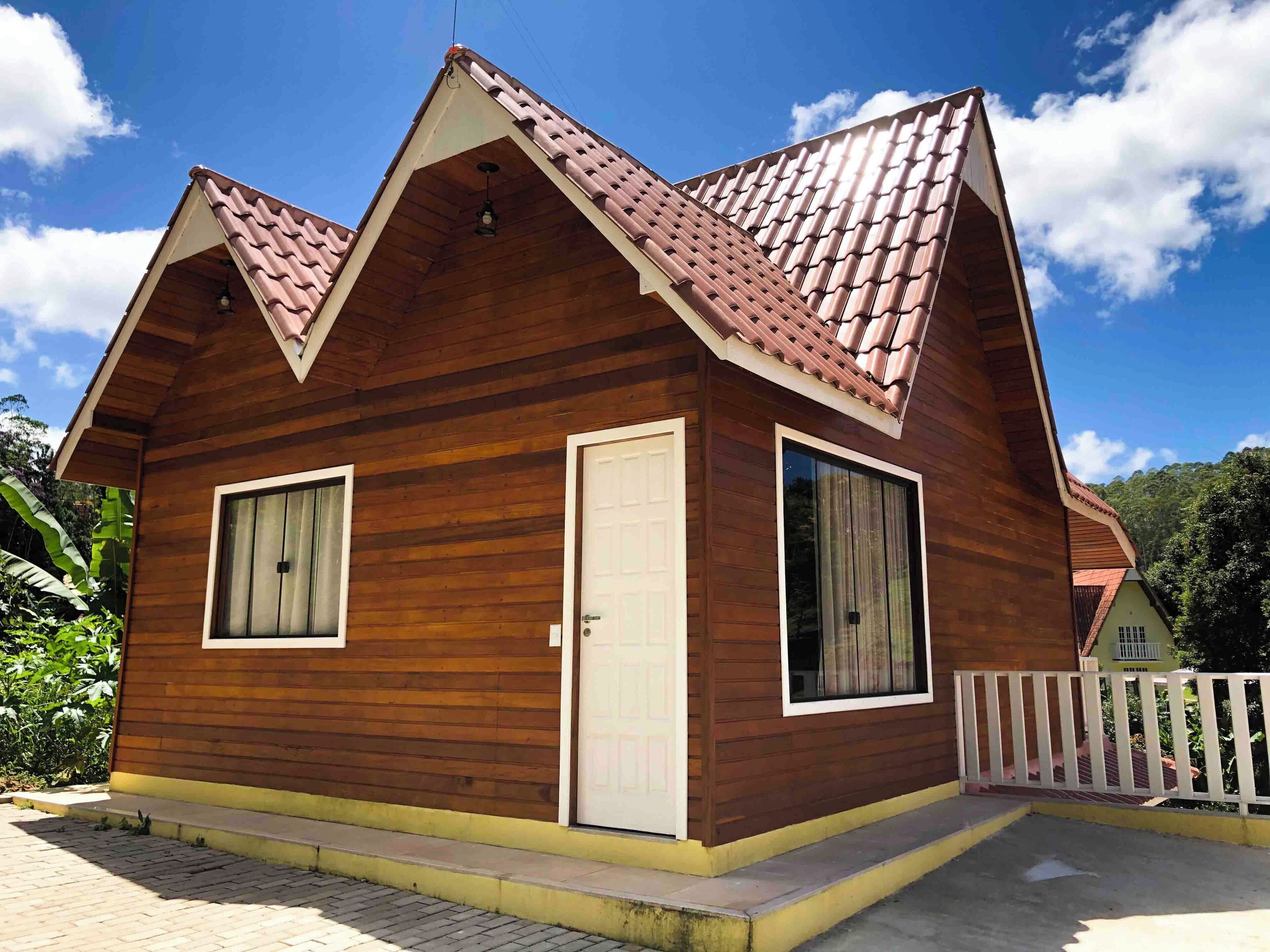 A wooden cabin with a pitched roof, two windows, and a door.