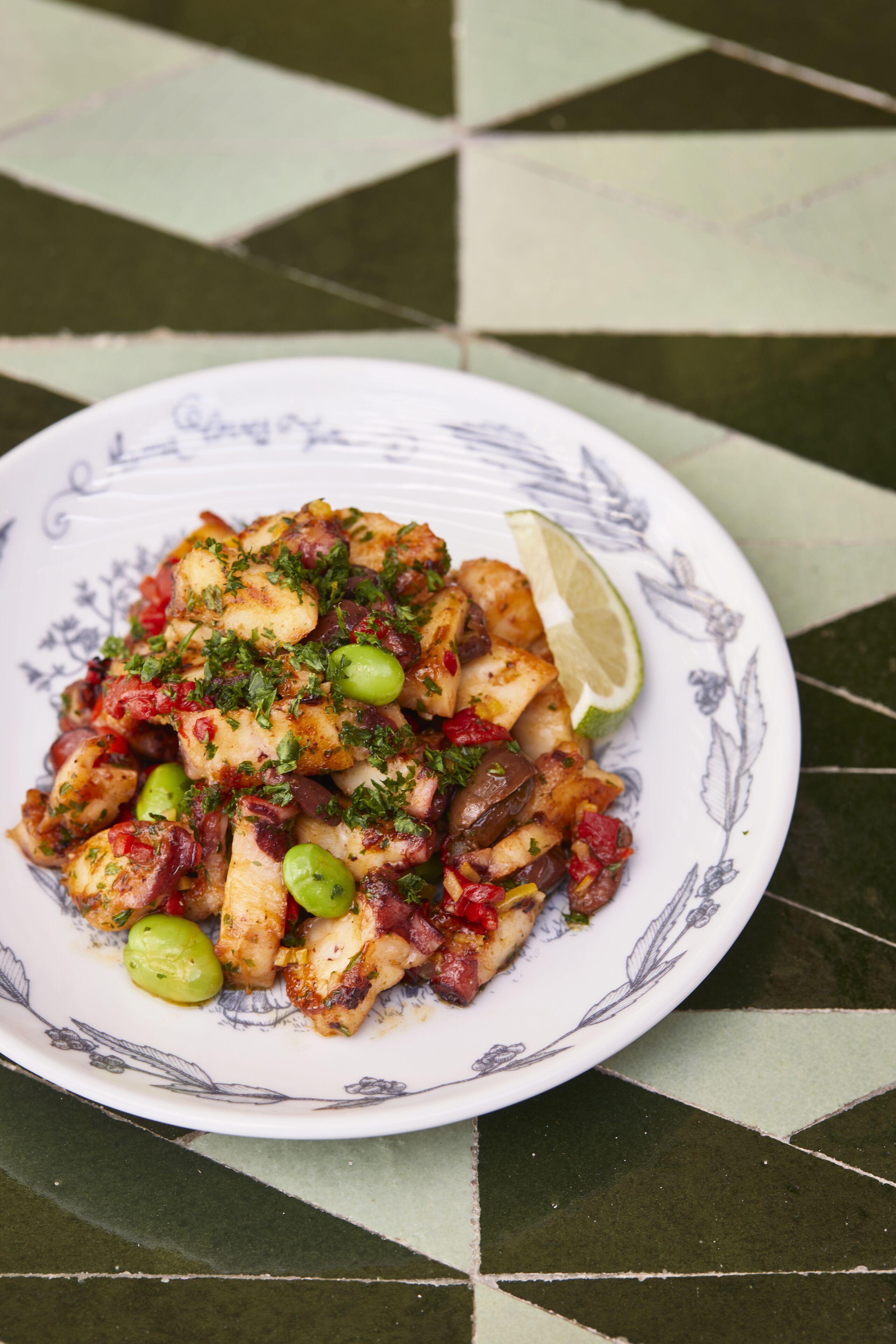 Une assiette remplie de différents aliments, posée sur une nappe à motifs.