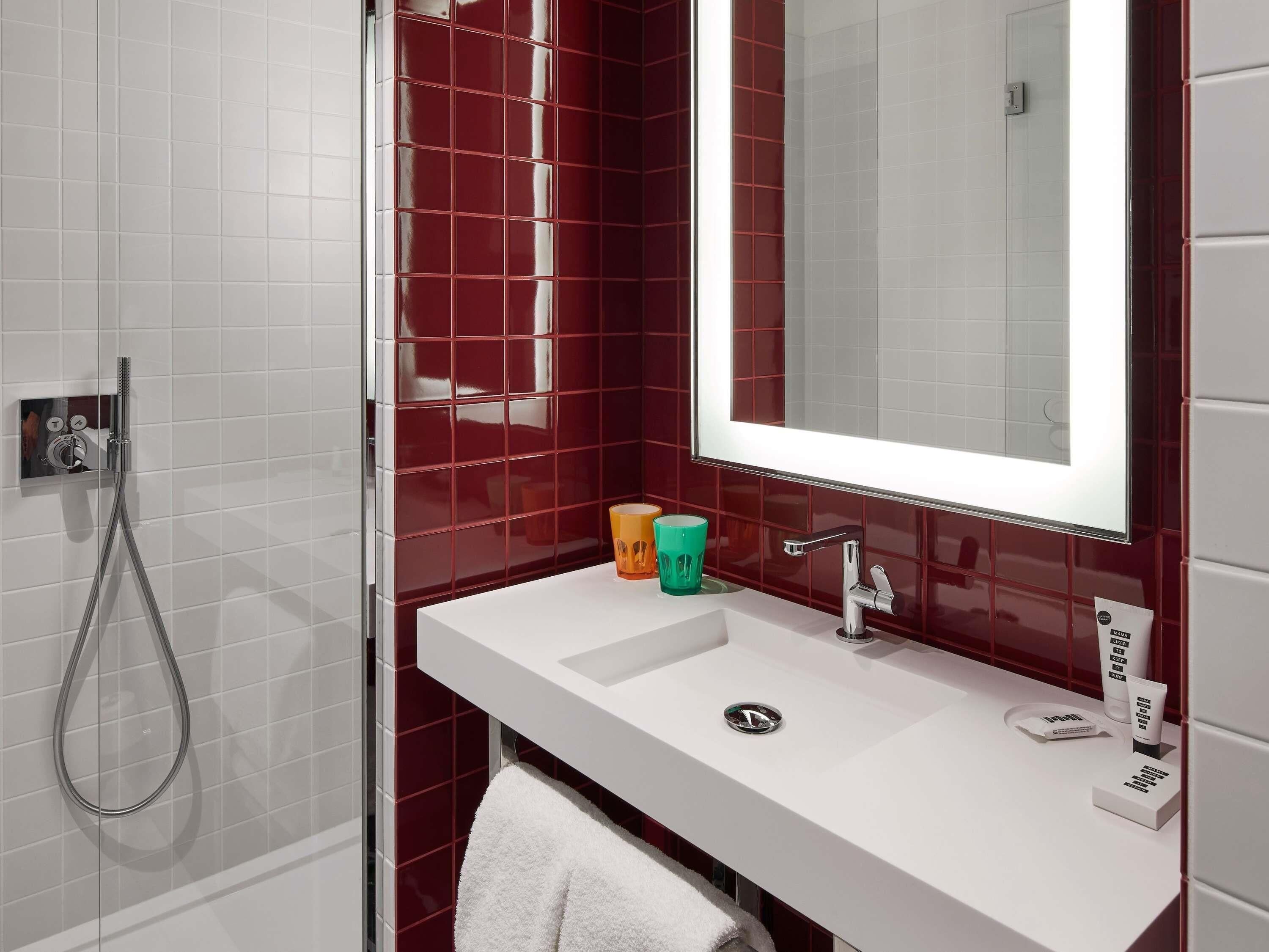 Un baño con lavamanos blanco, un espejo y una ducha.