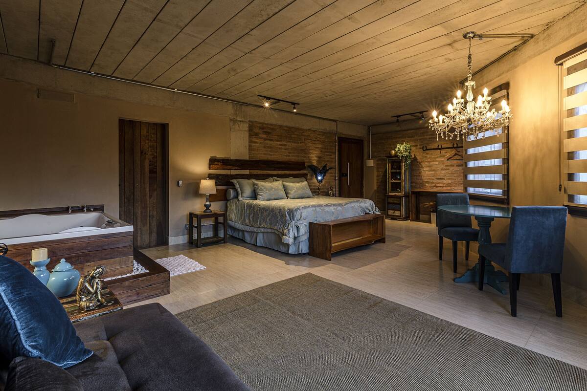 Ein Schlafzimmer mit einem großen Bett, einem Schreibtisch und einer Chandelier.
