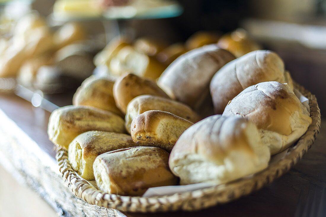Uma cesta com pães e doces variados.