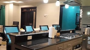 Una cucina moderna con isola centrale, forno integrato e ventilatore a soffitto.