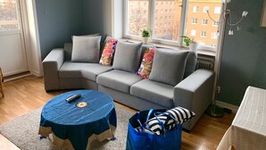 Ein Wohnzimmer mit einem grauen Sofa, einem blauen Tisch und einer blauen Tasche.