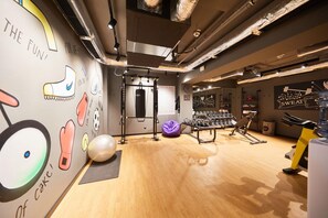 A gym with exercise equipment, a punching bag, and motivational posters on the walls. - Moxy Bucharest Old Town (Bucharest)