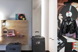 A room with a wooden wall, a suitcase, a pink suitcase, a drink, a pair of glasses, and a record player. - Moxy Bucharest Old Town (Bucharest)