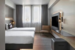 A hotel room with two beds, a TV, a chair, and a desk. - Moxy Bucharest Old Town (Bucharest)