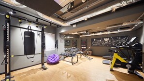A gym with exercise equipment, a punching bag, and motivational wall art. - Moxy Bucharest Old Town (Bucharest)