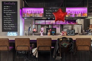 A bar area with a neon sign, a menu board, and a star decoration. - Moxy Bucharest Old Town (Bucharest)
