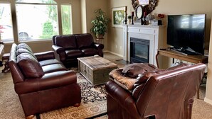 A living room with a fireplace, leather sofas, a coffee table, and a television. - 2 king 2 twin beds 3Bed 2.5 Ba cozy Mer Home near Village with Hot tub (Meridian)
