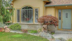 A single-story house with a yellow facade, a brick foundation, and a green door. - 2 king 2 twin beds 3Bed 2.5 Ba cozy Mer Home near Village with Hot tub (Meridian)