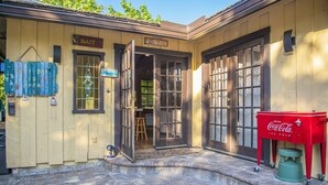 A building with a wooden exterior, a Coca-Cola cooler, and a sign that reads "BAIT". - Quaint Pool House in Tropical Setting (Boynton Beach)