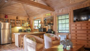 A wooden cabin interior with a kitchen, dining area, and living room. - Quaint Pool House in Tropical Setting (Boynton Beach)