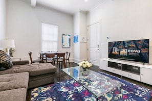 Relax in a stylish room with a sofa, flat-screen TV, and patterned rug.