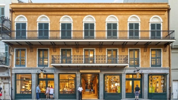 A two-story building with a ground-floor shop and upper-floor balconies.