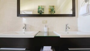 Un baño con dos lavamanos, un espejo y un perchero para toallas.