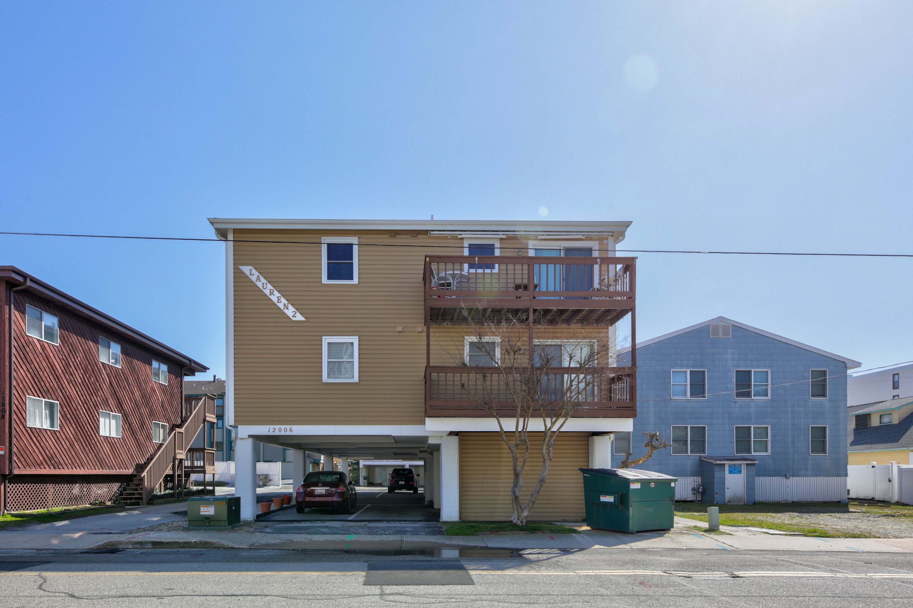 A two-story apartment building with a brown exterior and a balcony on the second floor.